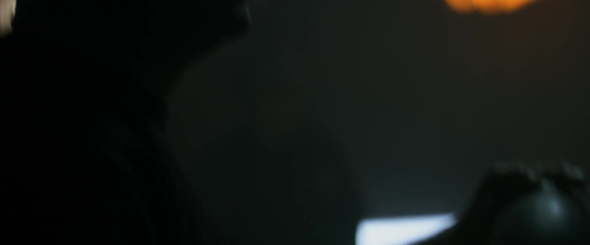 A man laughs in a dark room