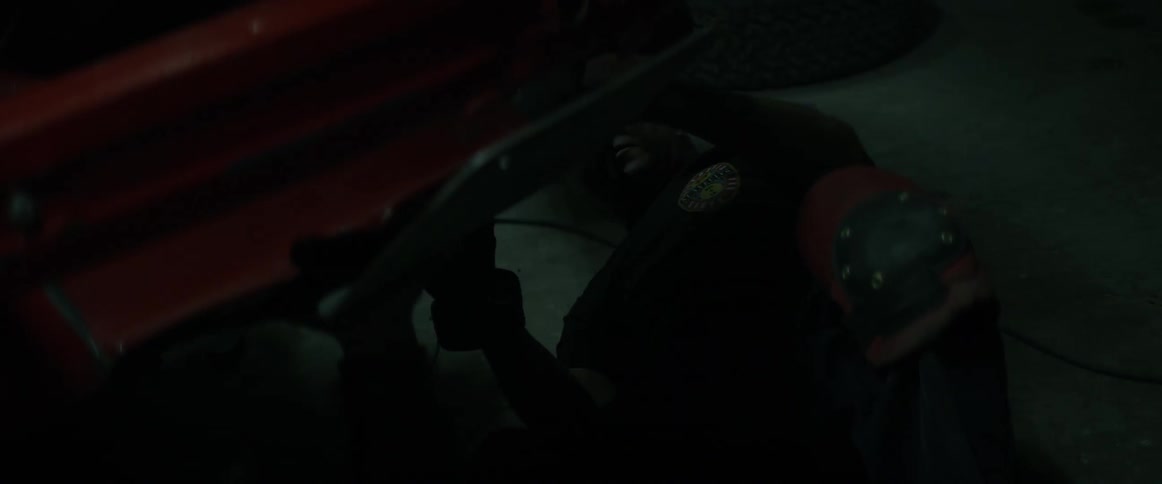 Mechanic crawls under a red vehicle
