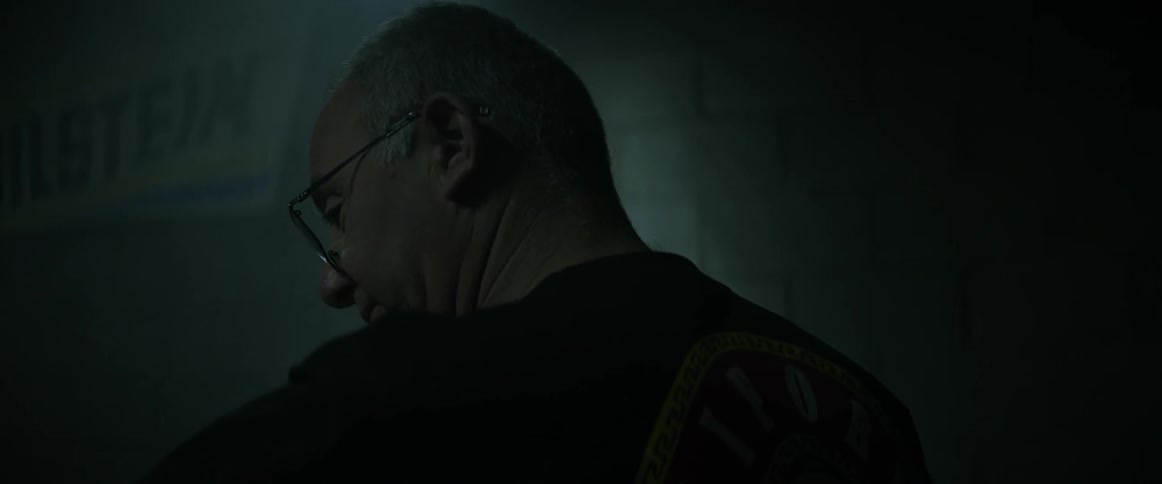 A man looks to the side towards a vehicle