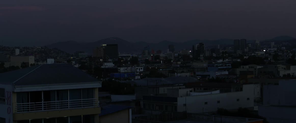 Tall city buildings tower into the sky at dusk