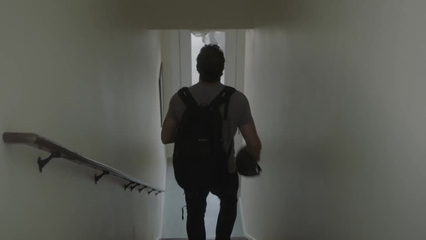 Man wearing a backpack exits a building