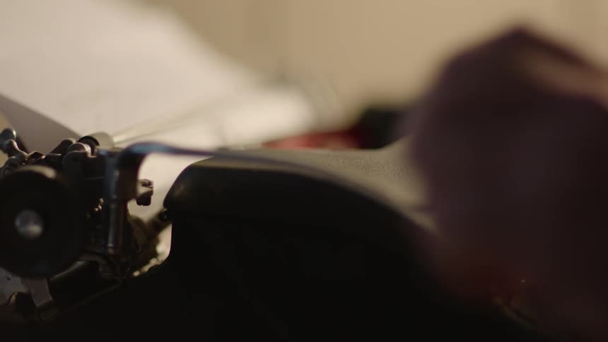 A person is using a typewriter during the day