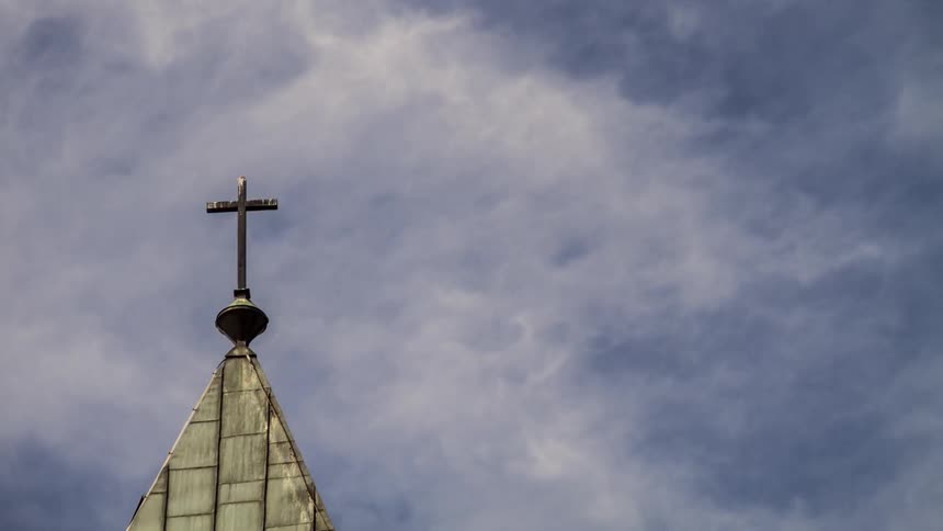 Clouds roll over a church steeple