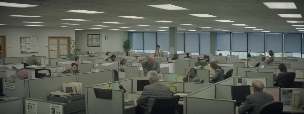 People in an office full of cubicles are working