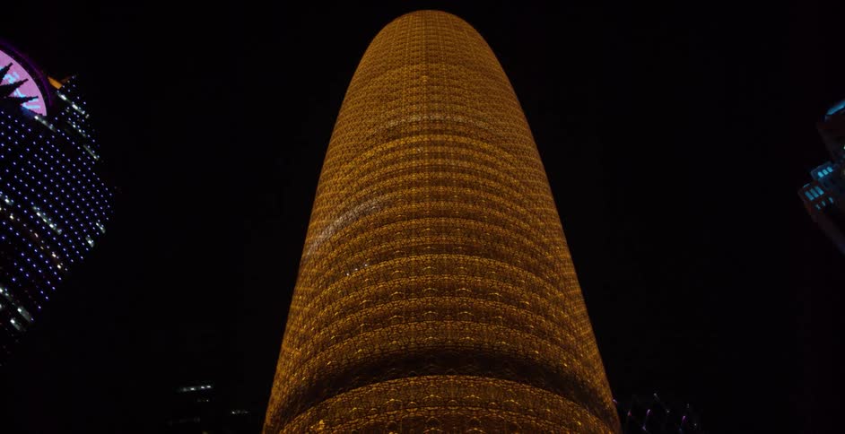 Tall lighted buildings against a night sky