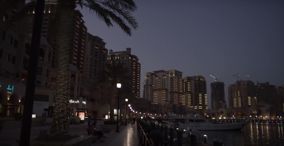 City buildings stand next to a bay at dusk