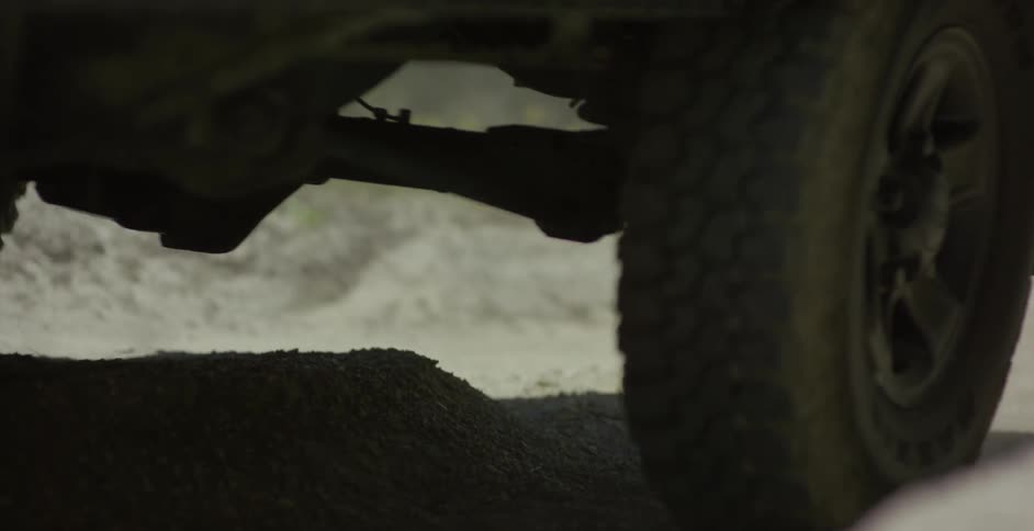 A vehicle drives on a dirt road