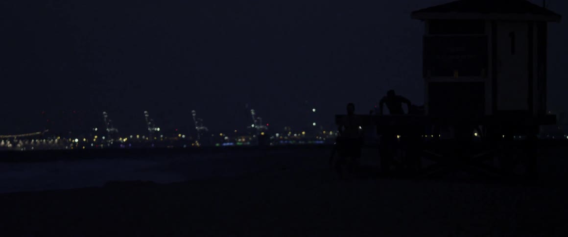 Silhouetted men jump from a platform at night