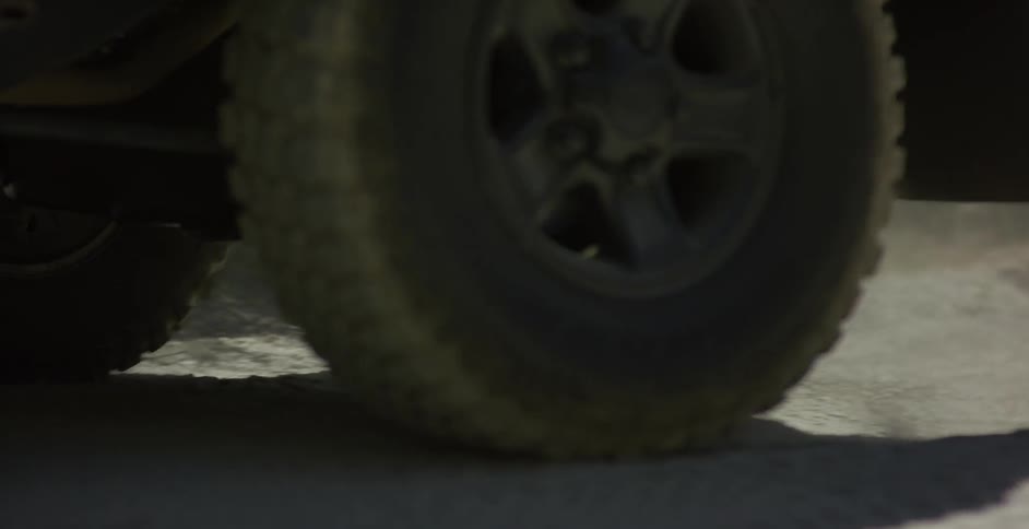 A vehicle drives across sand