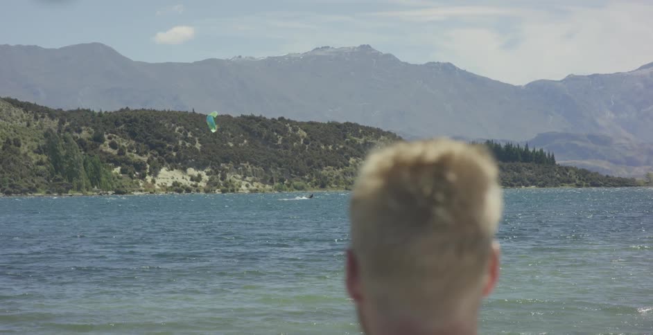 A man looks at a lake on a sunny day