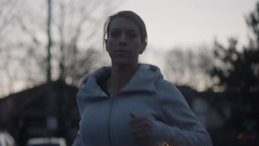 A woman is jogging in a residential area in the morning
