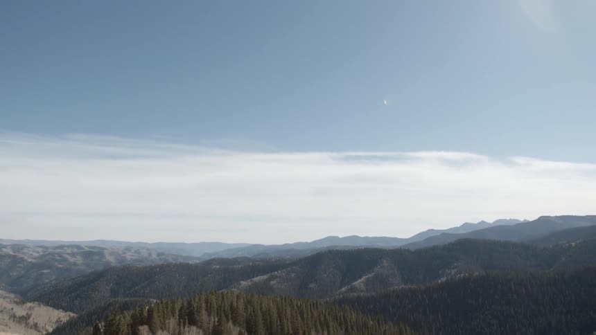 A mountain range and forest on a sunny day