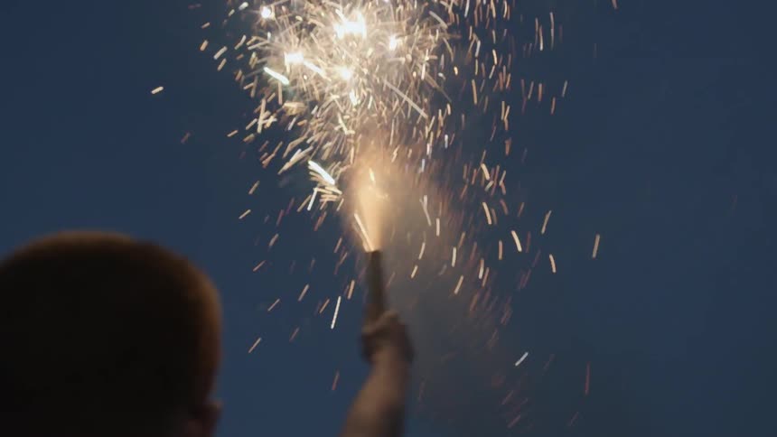 A man holds a flare high above his head
