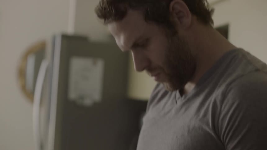 A man looks at his phone in the kitchen