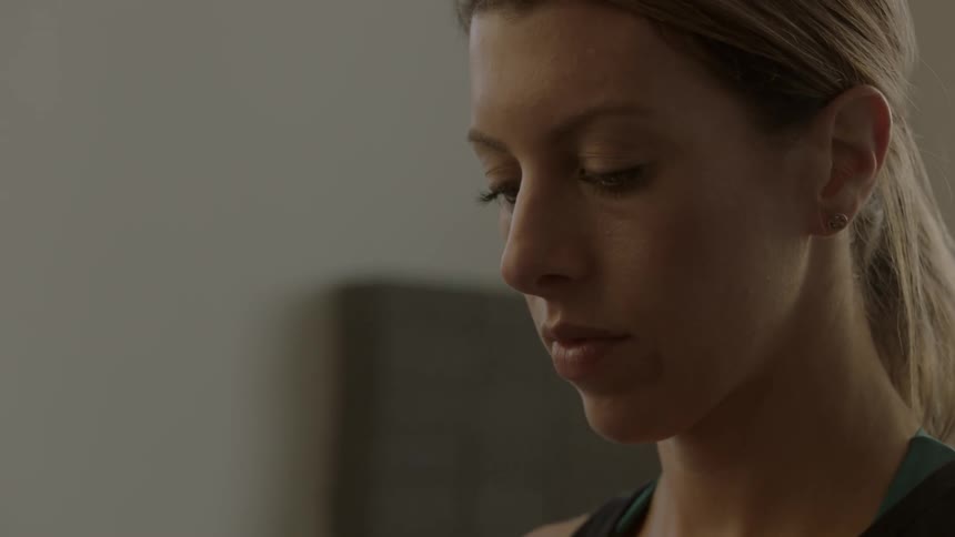 A woman in a room looks down at something