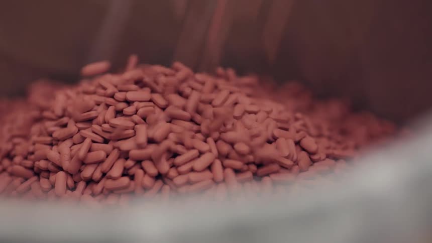 Pills fall and pile into a container