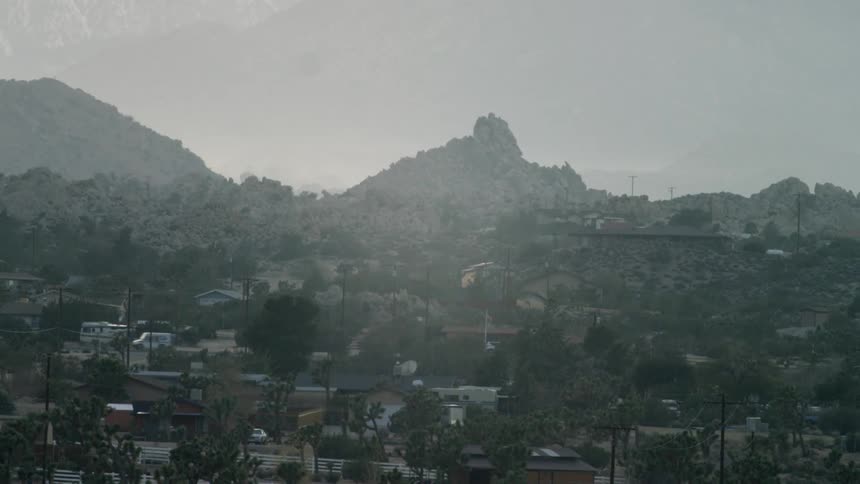Traffic flows on a road through a city in an arid region
