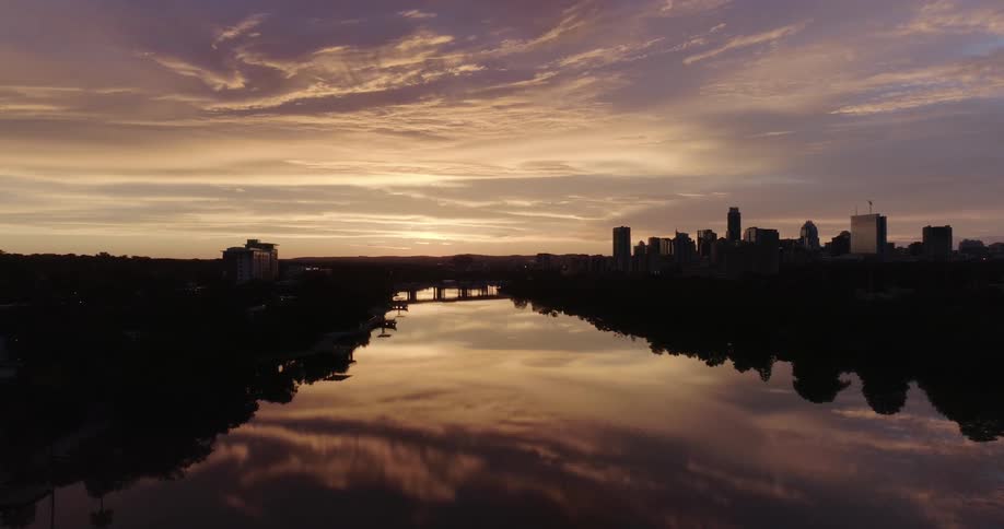 A sunset reflects on a calm body of water