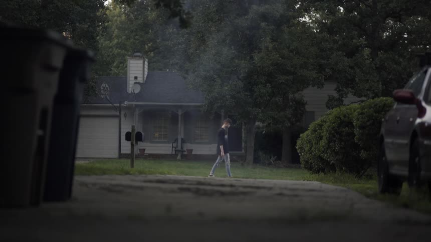 A man walks down a smokey street
