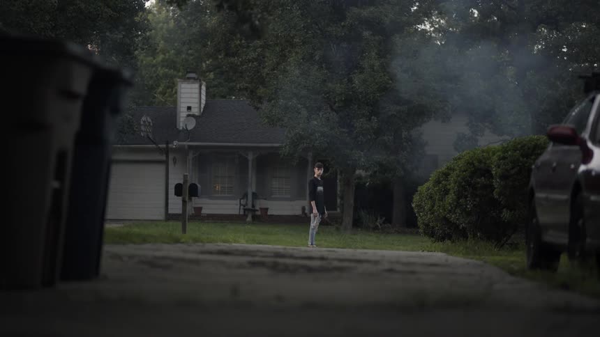 A man walks down a smokey road