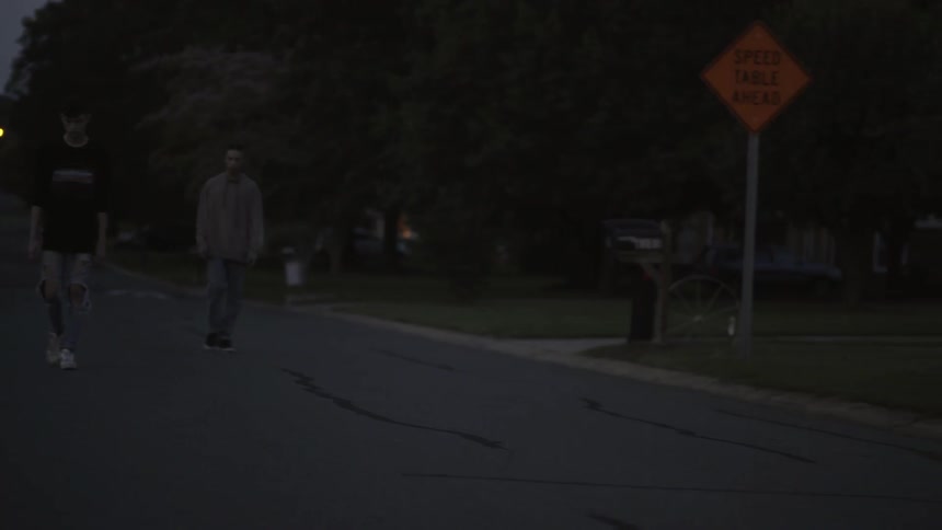 Two boys walk down a road