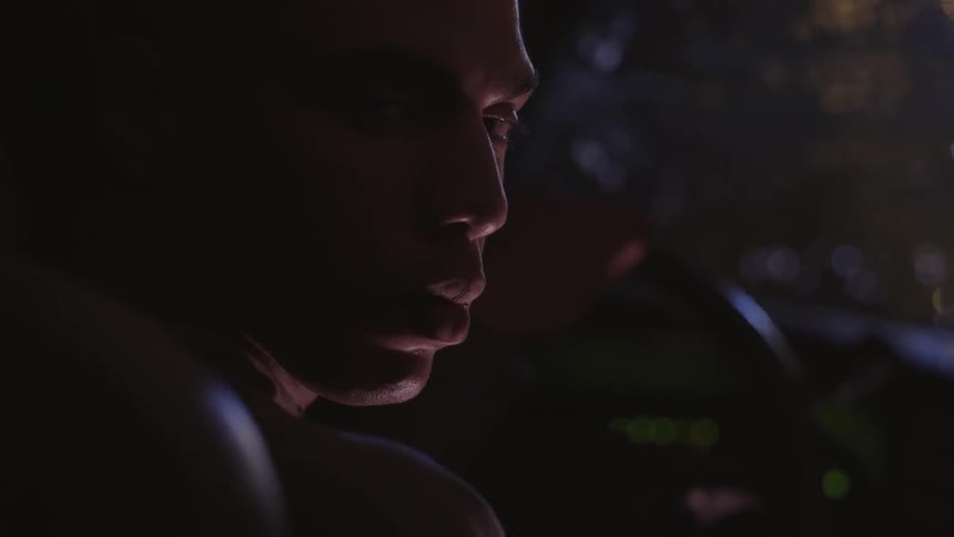 Man's sitting in a vehicle at night