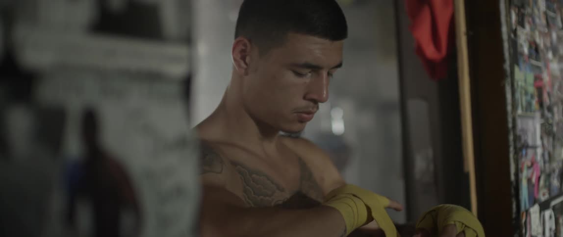 A white male boxer wraps his hand in fabric
