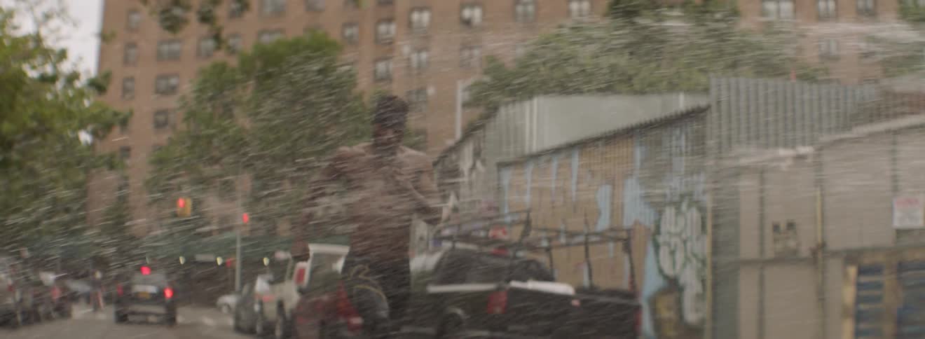 A man runs through spraying water