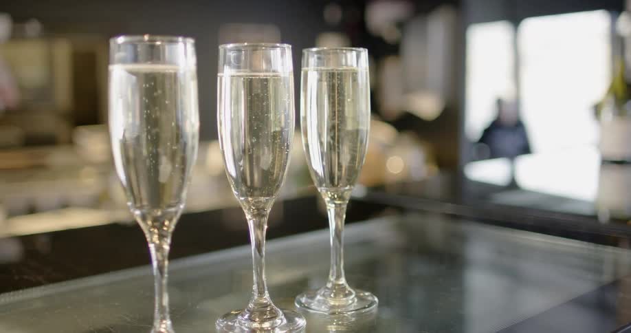Three glasses of champagne on a glass counter