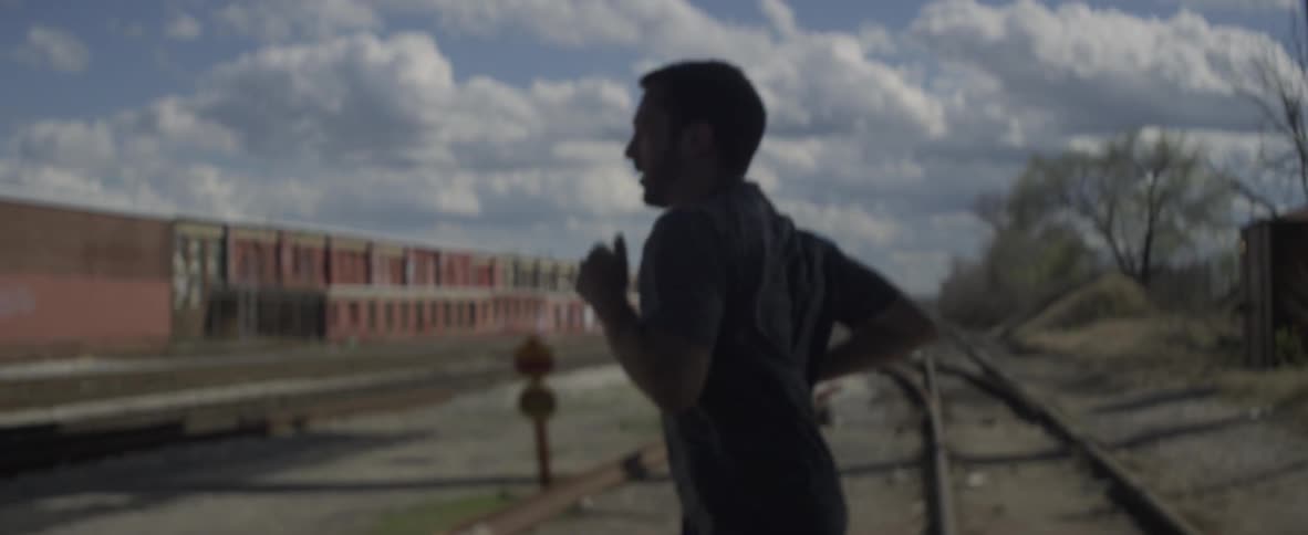 A man jogs outside near railroad tracks