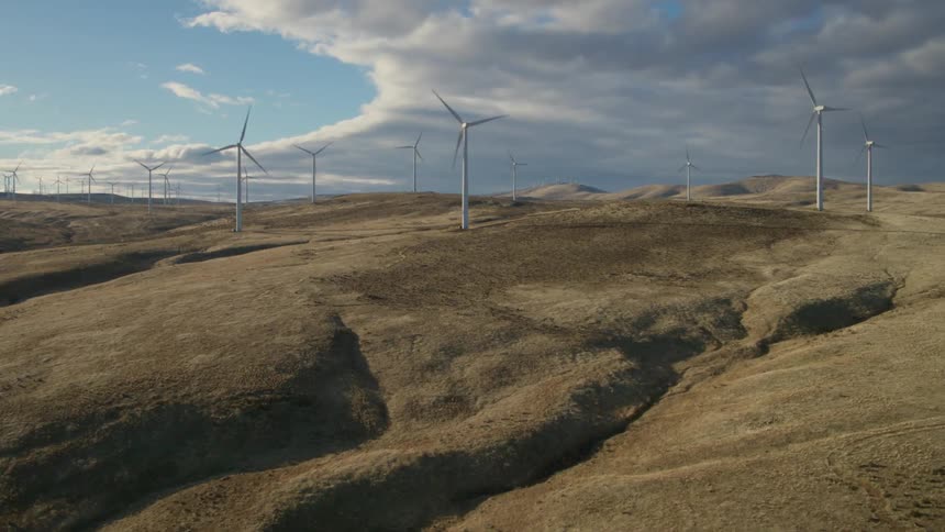 Wind turbines generating electricity along beautiful sagebrush hills