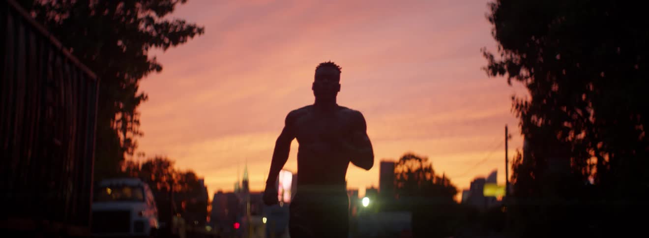 A shirtless man runs outside