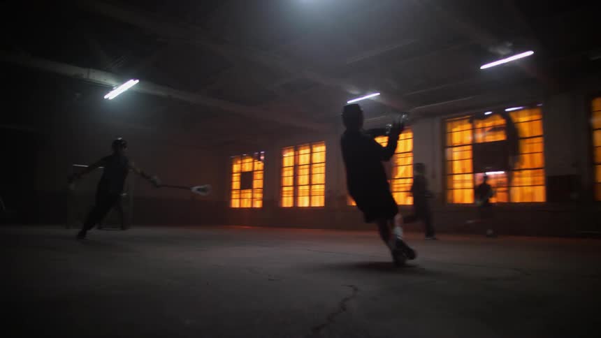 A man shoots the ball into the net after passing the other players