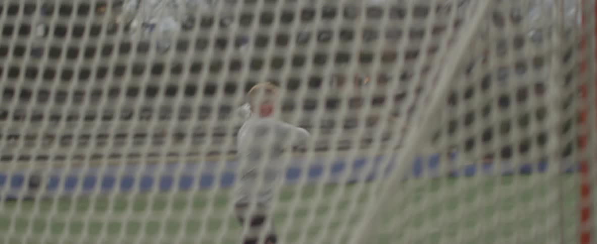 Man practices lacrosse outside in a field