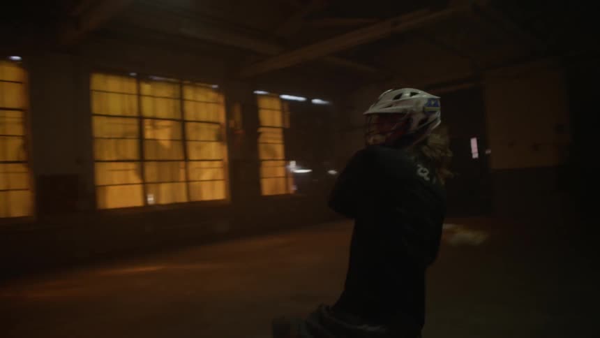 People play lacrosse in an abandoned building