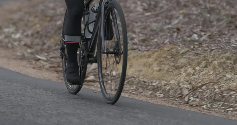 Two people are bicycling up a hill