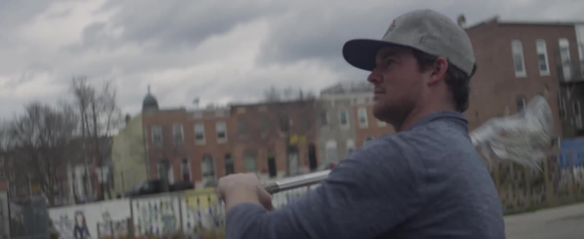 A man practices with a lacrosse bat