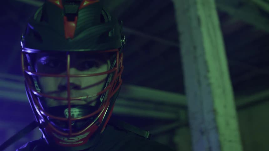 An athlete wearing a mask is standing indoors