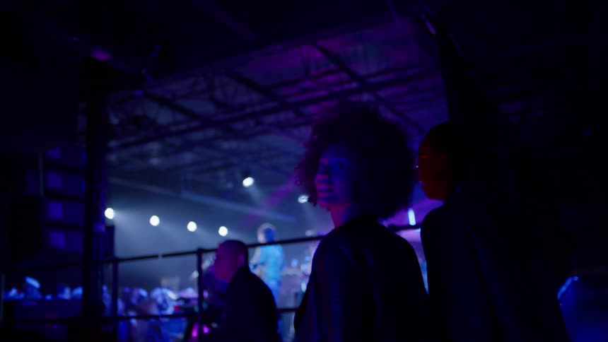 Woman walks into a dark nightclub and looks around