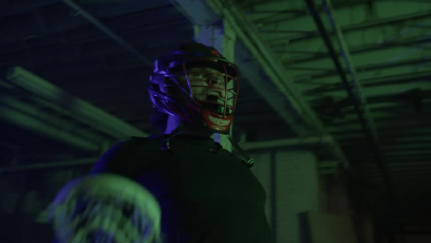 Man holding a lacrosse stick yells