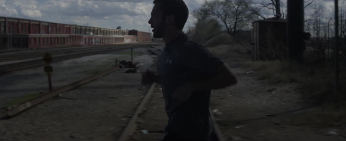 Man jogs through a desolate neighborhood on a cloudy evening