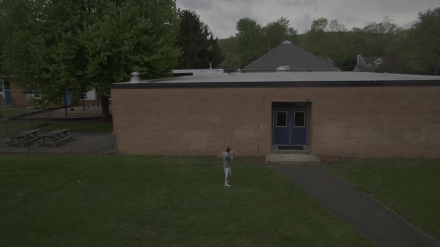 A man is throwing a lacrosse ball against the wall