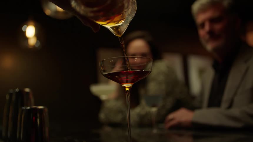 A bartender pours a drink