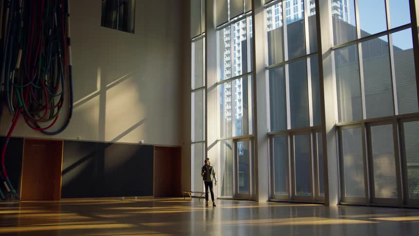 A man stands alone inside a large and empty room