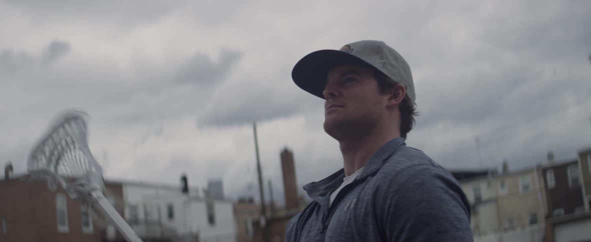 A man swings a lacrosse stick