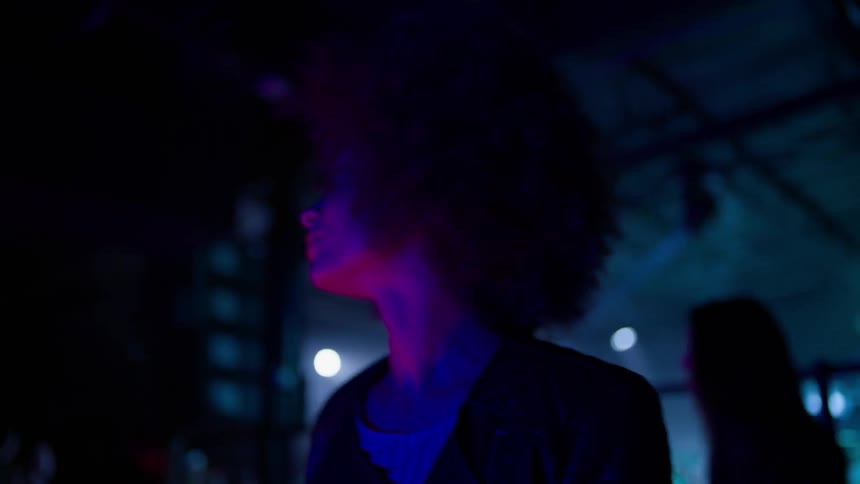 A woman walks around a club