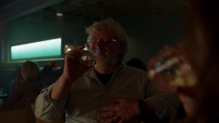 A man and woman drink at a bar