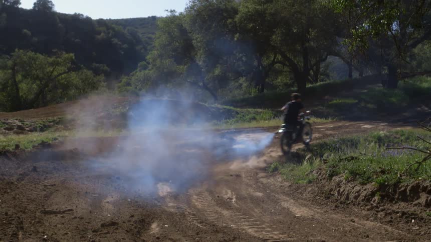 Man speeds on a dirt road on a dirt bike