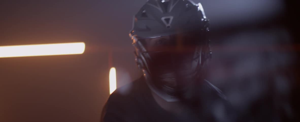 A lacrosse playing is waving a stick