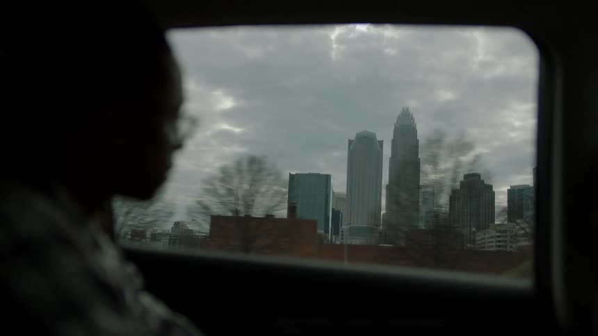 A person rides in a vehicle and looks out the window